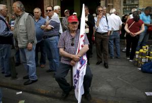 A Greek pensioner holds a flag during a demonstration for better healthcare in Athens